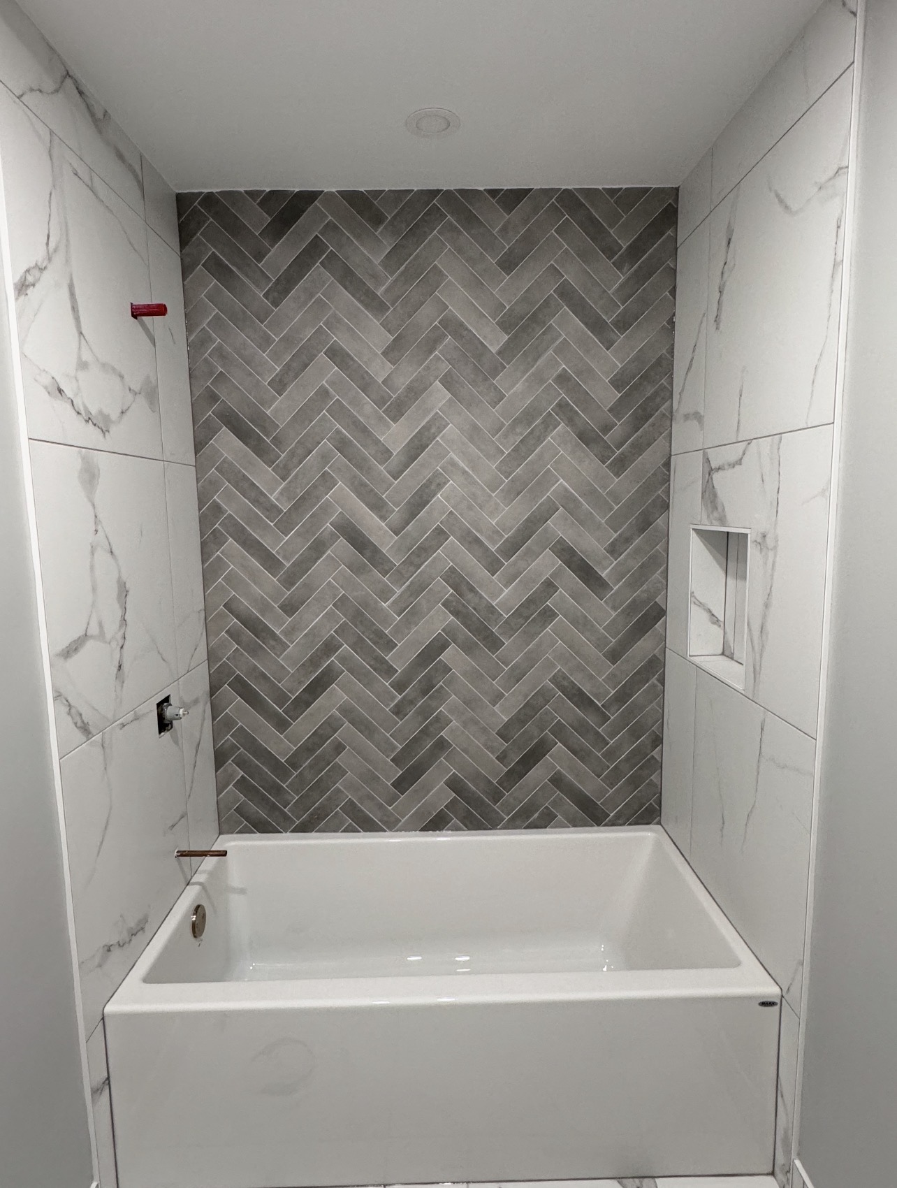 Herringbone tile master ensuite completed by Symmetrical Flooring in Orléans